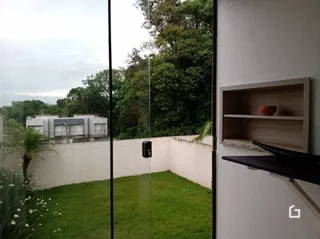 Vista externa de um jardim gramado com muro branco.