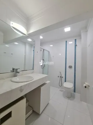 Foto de um banheiro moderno com revestimento branco e bancada clara.