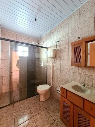 Parede interna com revestimento cerâmico e porta de madeira em uma residência.