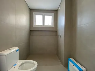Banheiro simples com paredes claras e uma janela.