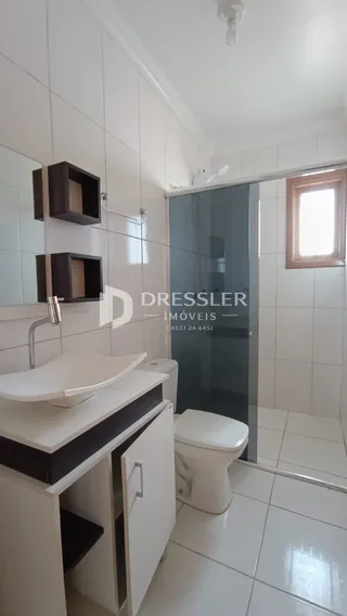 Foto de um banheiro interno com revestimento cerâmico branco.