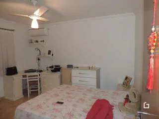 Quarto com cama e parede branca em uma residência.