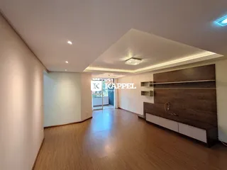 Sala de estar com piso de madeira e painel decorativo na residência.