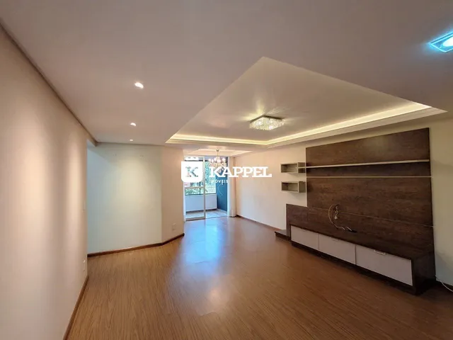 Sala de estar com piso de madeira e painel decorativo na residência.