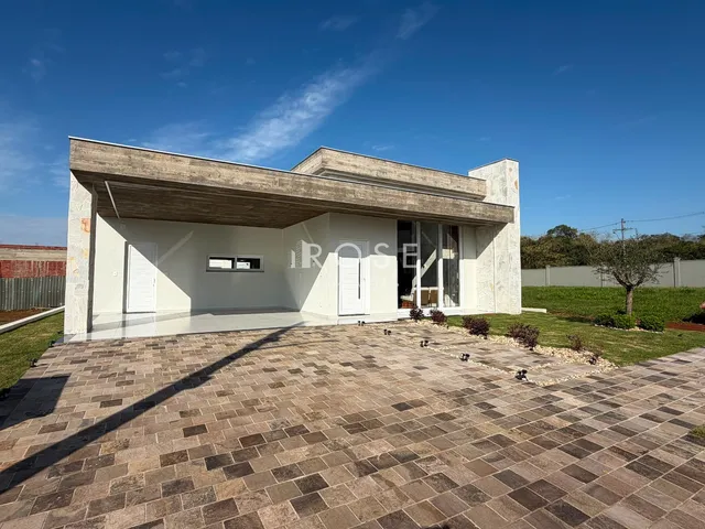Fachada de uma casa moderna com área externa pavimentada.