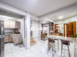 Foto de uma sala de estar e cozinha com piso de cerâmica clara.