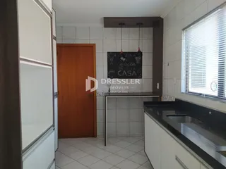 Interior de uma cozinha moderna com piso de cerâmica e armários brancos.