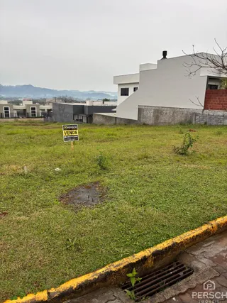 Fachada de uma residência moderna em Lajeado, Brasil, com área gramada em primeiro plano.