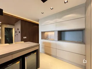 Cozinha moderna com armários de madeira e bancada clara.