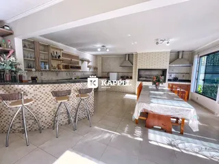 Foto interna de uma cozinha com bancadas e área de refeições.