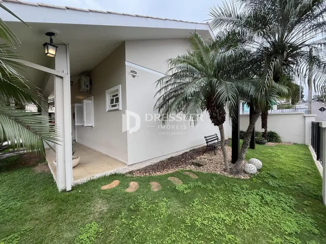 Fachada de uma residência com jardim e palmeiras em Lajeado, Brasil.