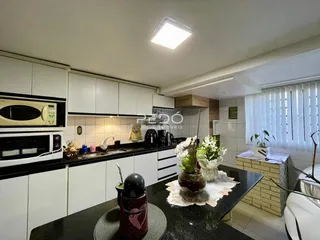 Cozinha moderna com armários brancos e bancadas pretas em Lajeado.