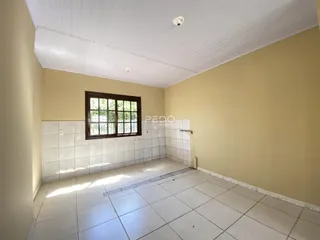 Vista interna de um corredor com piso de cerâmica branca.