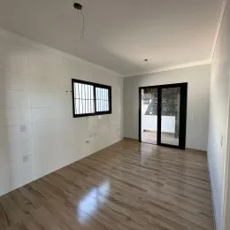 Sala de estar com piso de madeira clara e paredes brancas.