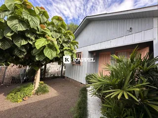 Fachada de uma residência em Lajeado, Brasil, com vegetação exuberante ao redor.
