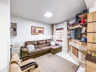 Sala de estar com sofá e televisão em um apartamento.