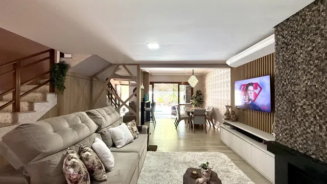 Sala de estar com decoração moderna e acesso a uma área de jantar.
