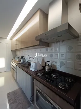 Cozinha moderna com armários de madeira e revestimento branco.