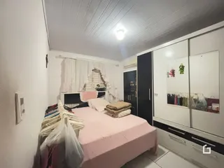 A foto mostra um quarto com cama e armários em um imóvel.