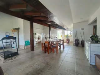Foto de uma área comum com piso de cerâmica e estrutura de madeira exposta.