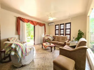 Sala de estar com sofá e cortinas em um imóvel em Lajeado.