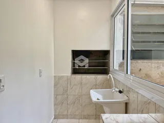 Uma área interna com paredes brancas e revestimento de azulejos claros.