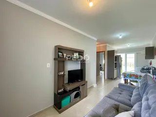 Sala de estar com sofá e rack de TV em um imóvel no Brasil.