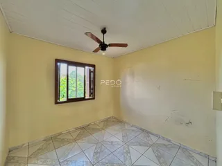 A sala apresenta um teto branco e piso de cerâmica com uma janela.