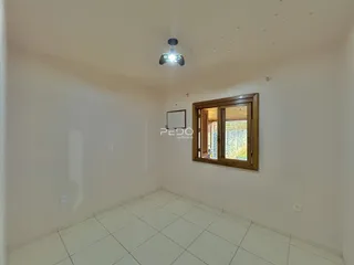 Ambiente interno de uma sala com piso de cerâmica e parede branca.