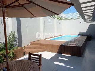 Vista externa de uma piscina e deck em uma propriedade no Brasil.