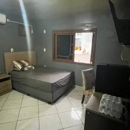 Quarto com cama de casal e piso de cerâmica em um imóvel.