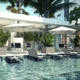Foto de uma piscina externa com vegetação tropical ao ar livre.