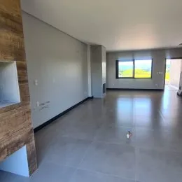 Vista interna de um espaço amplo com piso claro e paredes brancas.