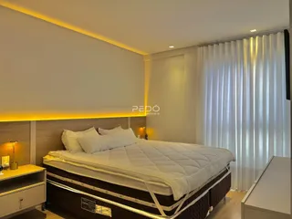 Quarto moderno com cama grande e iluminação de destaque.