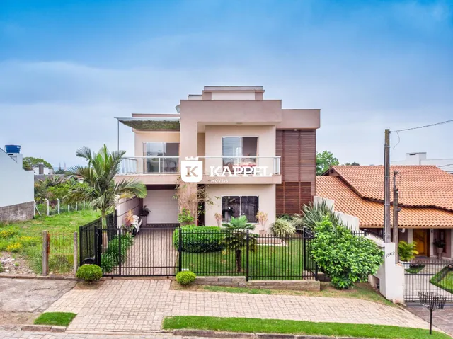 Fachada de uma casa moderna em Lajeado, Brasil, com jardim frontal e cerca.