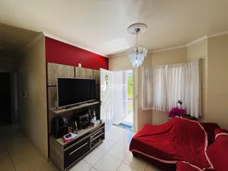 Interior de uma sala de estar com parede vermelha e piso de cerâmica.