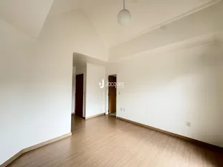 Hall de entrada com piso de madeira e paredes brancas.