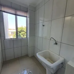 Foto de um banheiro com paredes brancas e piso de azulejo claro.
