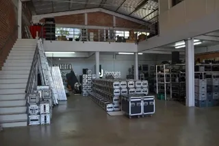 Interior de um espaço com paredes de tijolo aparente e escadas em um ambiente de armazenamento.
