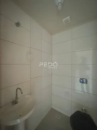 Foto de um banheiro com revestimento branco nas paredes.