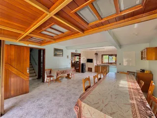 Interior de uma sala de jantar com piso de cerâmica e forro de madeira.