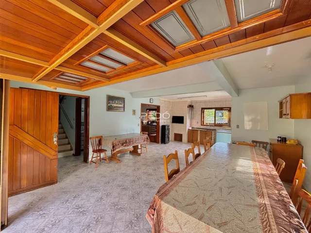 Interior de uma sala de jantar com piso de cerâmica e forro de madeira.