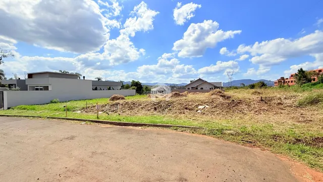 Vista externa da propriedade com terreno e vegetação seca em frente às residências.