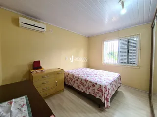Quarto com cama e armário de madeira na residência.