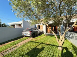 Foto da fachada de uma casa em Lajeado, Brasil, com jardim e árvore.