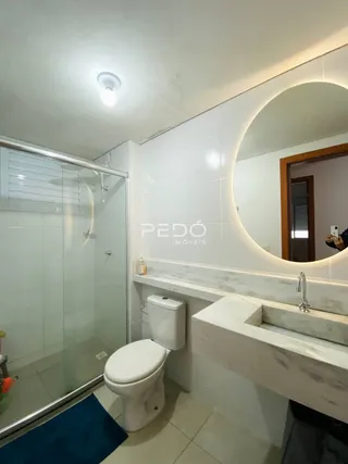 Foto de um banheiro com revestimento branco e piso claro.