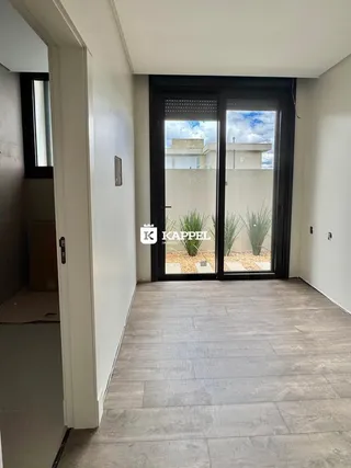 Hall de entrada com portas de vidro que dão vista para o exterior.