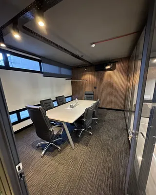 Sala de reunião com mesa e cadeiras em ambiente interno.