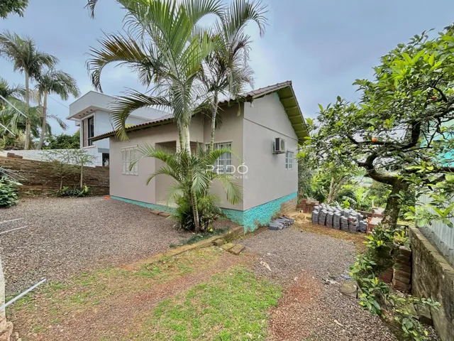 Fachada de uma casa em Lajeado, Brasil, com jardim e área de terra batida.