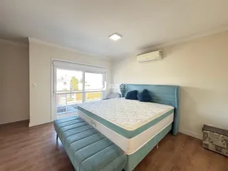 Quarto com cama e janela de vidro.
